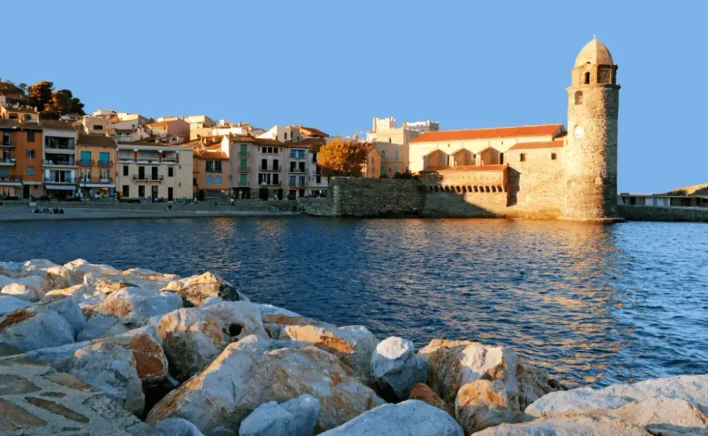 Small beach and the church of the Collioure in the evening sunset 